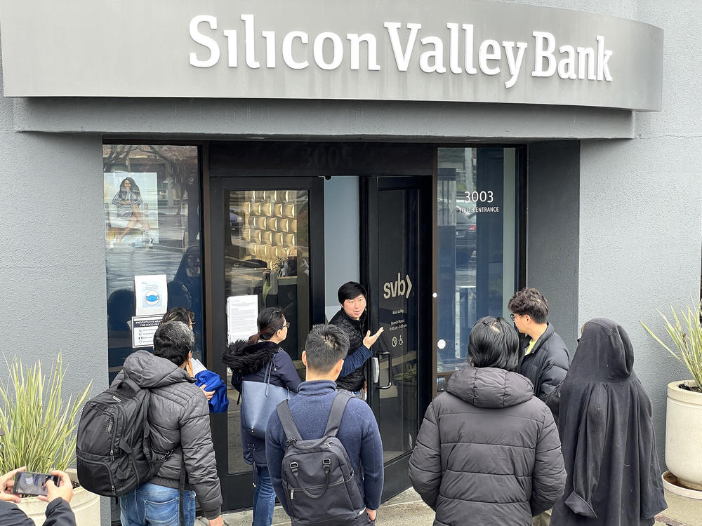 A worker tells people that the Silicon Valley Bank (SVB) headquarters in Santa Clara, Calif., is closed on March 10. Federal regulators took extraordinary measures on Sunday to backstop all deposits at SVB after the lender's spectacular collapse.