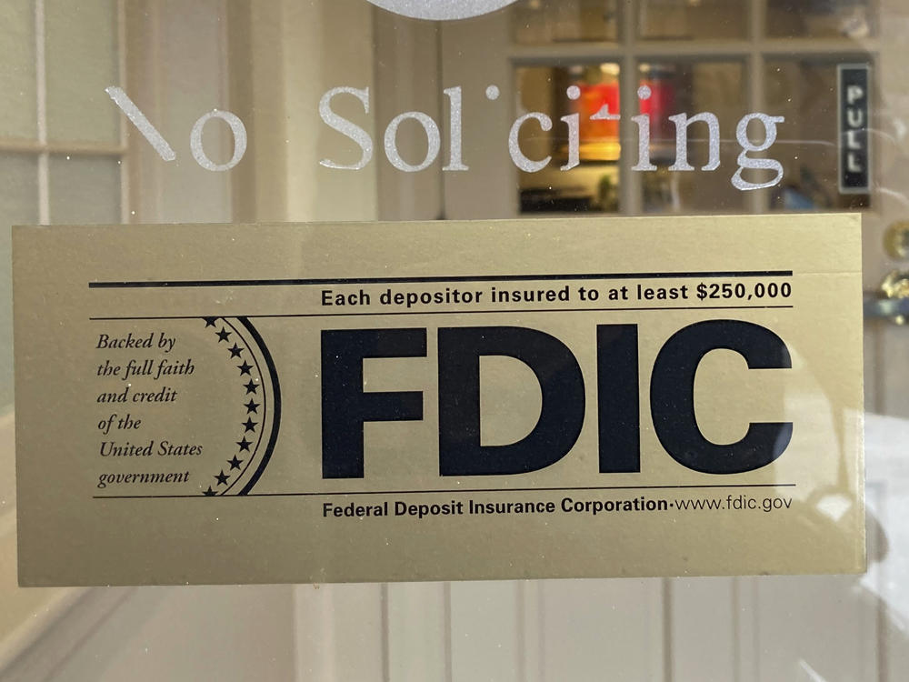 An FDIC sign is posted on a window at a Silicon Valley Bank branch in Wellesley, Mass., on Saturday. The bank was caught in a meltdown, forcing a government takeover. The FDIC guarantees accounts up to $250,000.