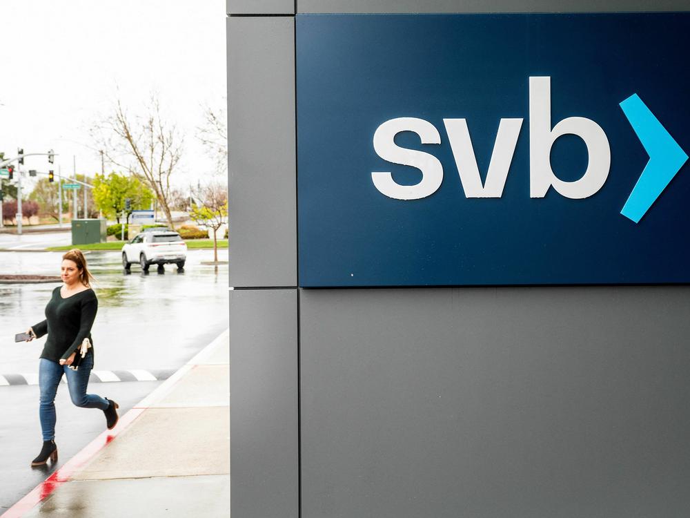 A property manager representative passes a sign at Silicon Valley Banks headquarters in Santa Clara, California on March 10, 2023.