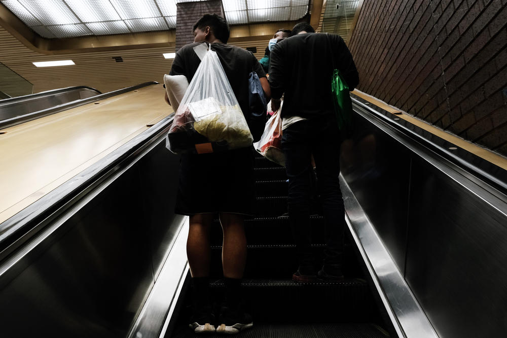 Migrants who crossed the border from Mexico into Texas walk through the Port Authority bus station in Manhattan after arriving by bus on August 25, 2022.