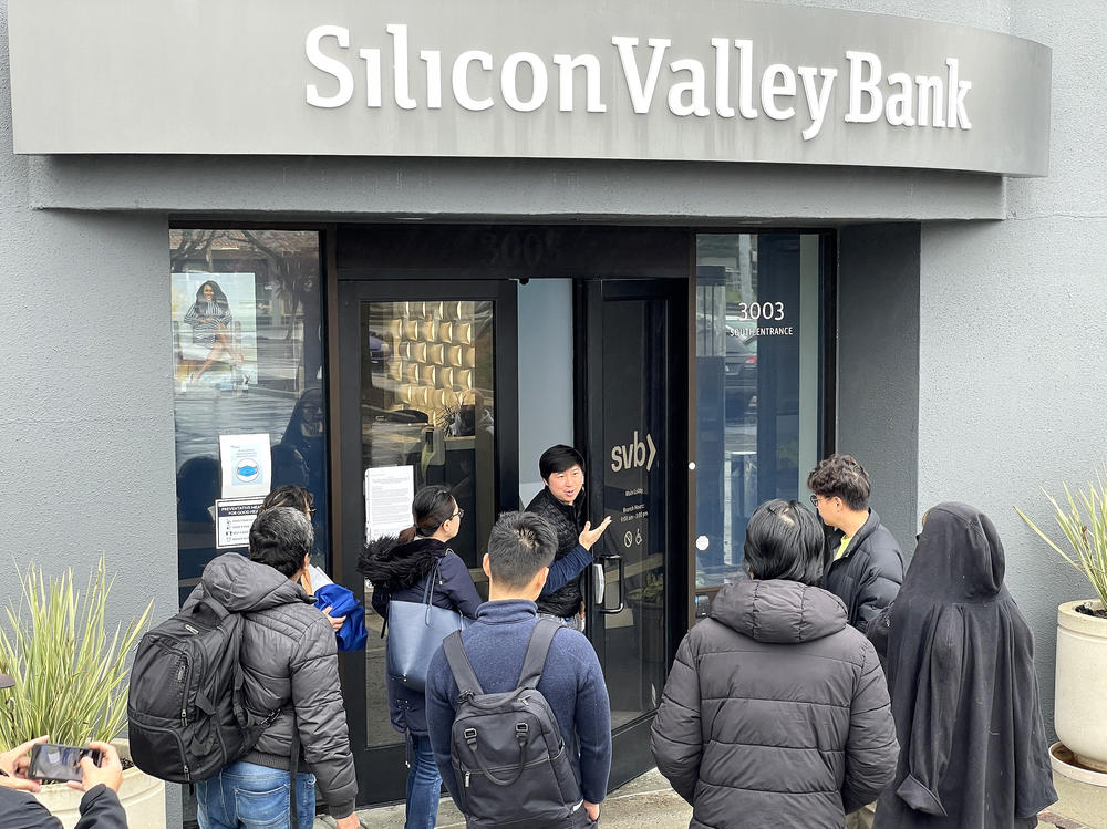 SANTA CLARA, CALIFORNIA - MARCH 10: A worker (C) tells people that the Silicon Valley Bank (SVB) headquarters is closed on March 10, 2023 in Santa Clara, California.