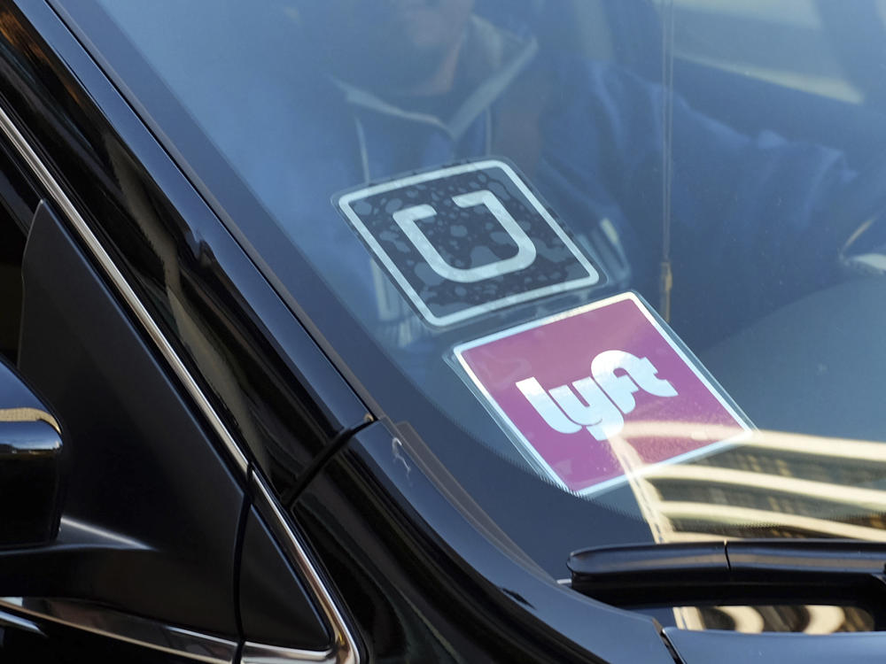 In this Jan. 12, 2016, file photo, a ride share car displays Lyft and Uber stickers on its front windshield in downtown Los Angeles. A California appeals court ruled March 13, 2023, that a voter-backed initiative exempting Uber and Lyft from a key provision of state employment law is constitutional, a reversal of a lower court decision that marks a win for the ride-hailing giants.