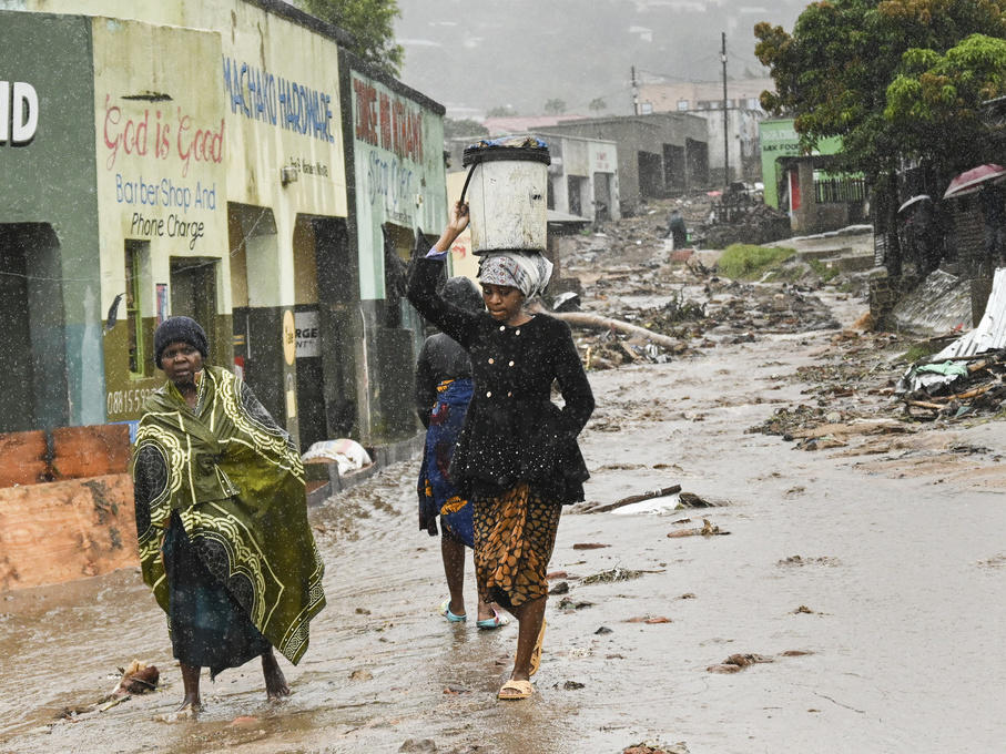 Women walk to a nearby displacement center in Blantyre, Malawi, on Tuesday. The unrelenting Cyclone Freddy, which is still battering southern Africa, has killed hundreds of people in Malawi and Mozambique since it struck the continent for a second time on Saturday night.
