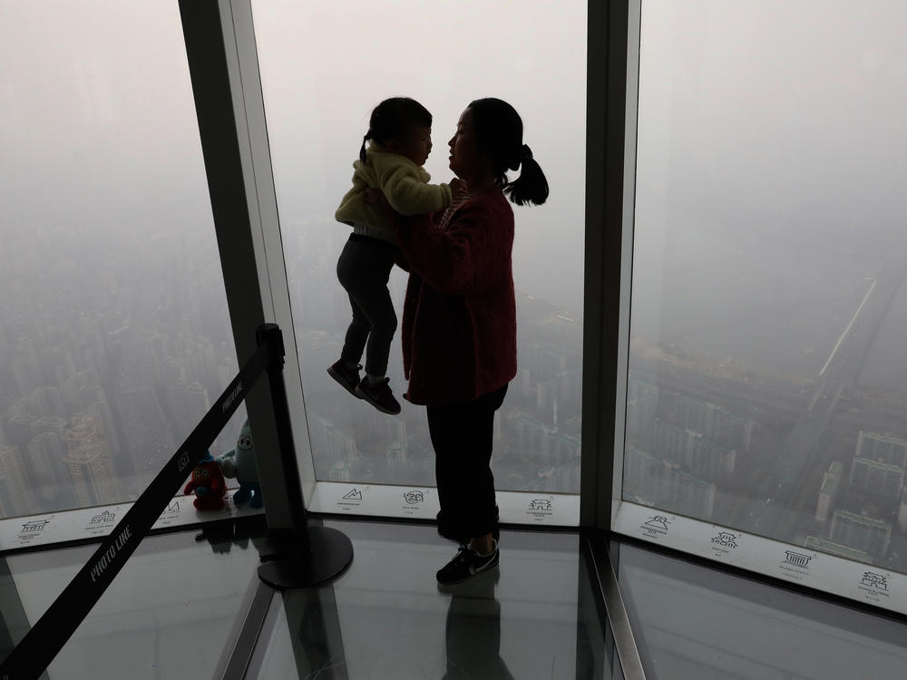 A woman holding her daughter looks at a view of Seoul in 2019. The fertility rate in South Korea, which has the world's lowest rate, hit 0.78 in February.