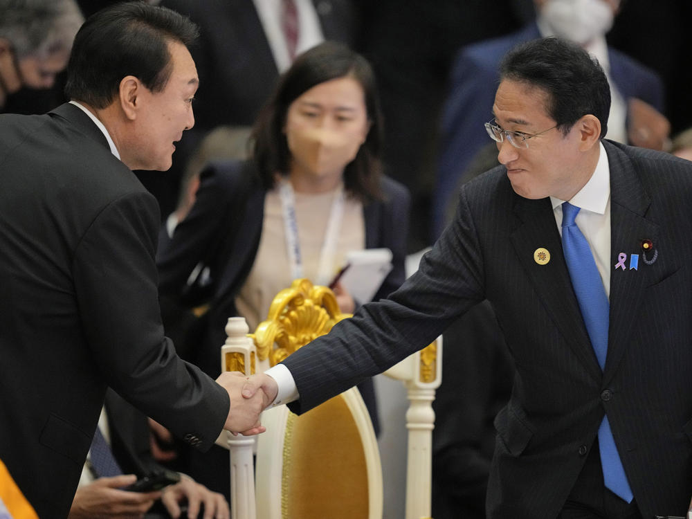 Japan's Prime Minister Fumio Kishida (right) shakes hands with South Korea's President Yoon Suk Yeol during the ASEAN summit in Phnom Penh, Cambodia, on Nov. 13, 2022. The two leaders will meet in Tokyo on Thursday in the first bilateral summit between Japan and South Korea in more than a decade, in hopes of overcoming tensions that date back more than 100 years.