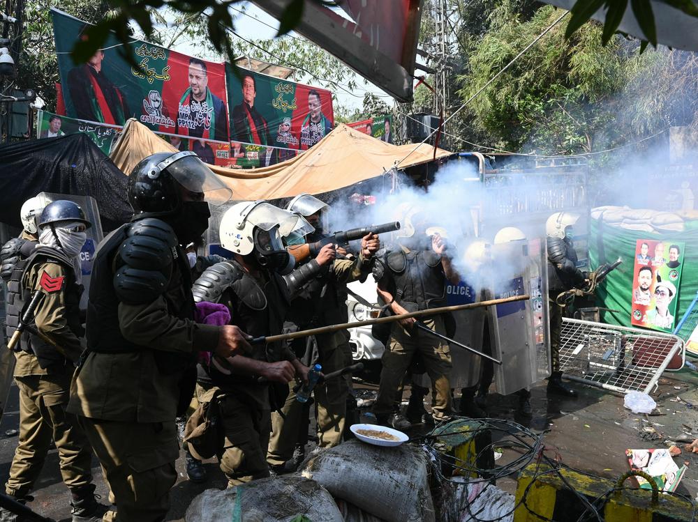 Riot police fire tear gas shells toward supporters of former Prime Minister Imran Khan gathered near Khan's house to prevent officers from arresting him, in Lahore, Pakistan, on Wednesday. The police withdrew later in the day.