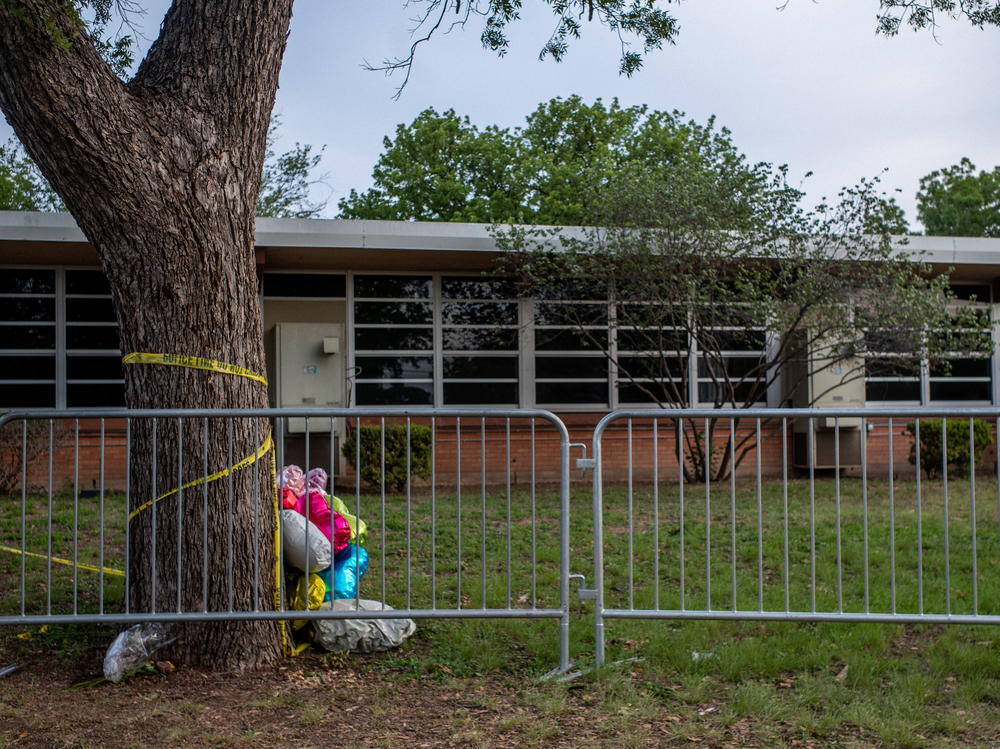 Balloons are seen wrapped around a tree in caution tape at Robb Elementary School on May 31, 2022 in Uvalde, Texas, a week after the school shooting.