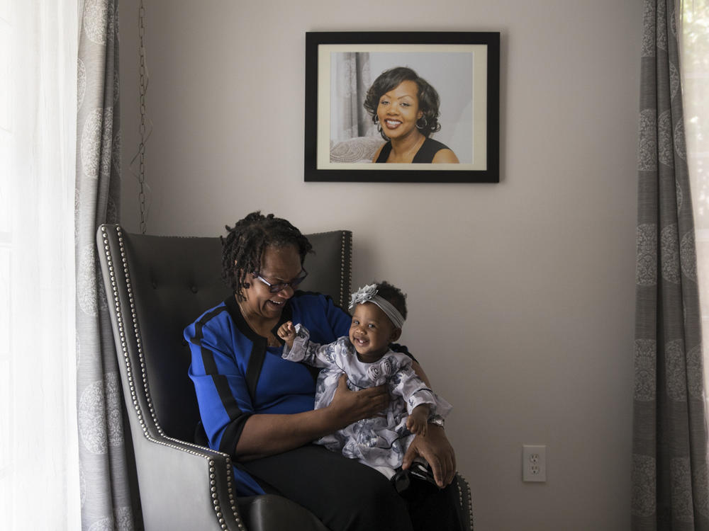 Wanda Irving holds her granddaughter, Soleil, in front of a portrait of Soleil's mother, Shalon Irving, at her home in Sandy Springs, Ga., in 2017. Wanda is raising Soleil since Shalon died of complications due to hypertension a few weeks after giving birth.