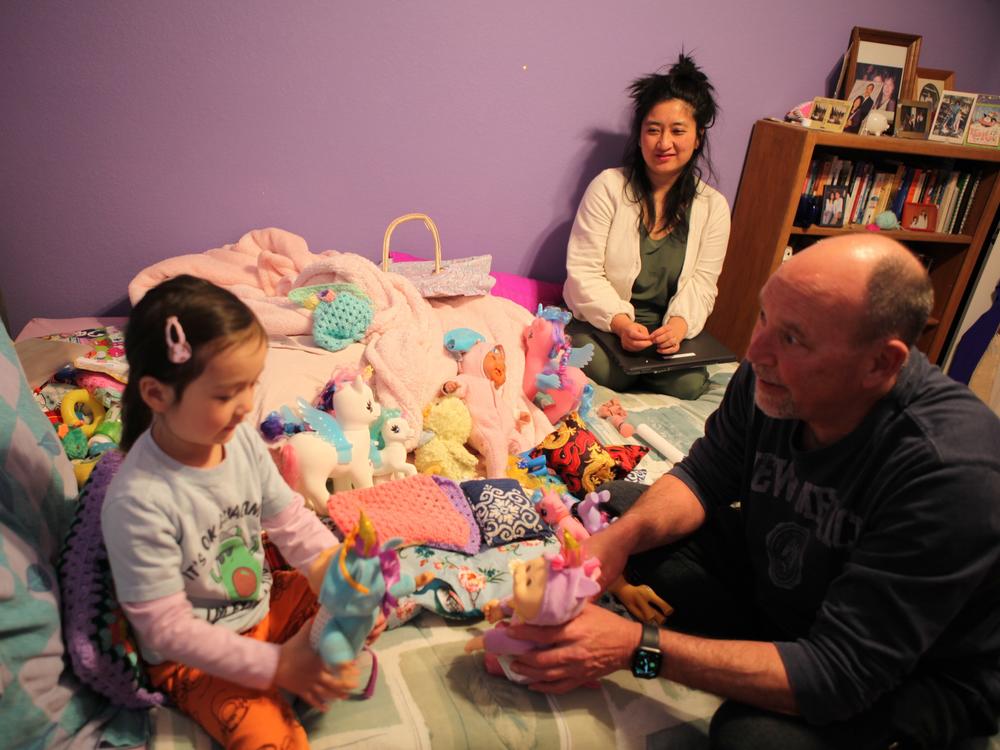 Former state lawmaker Kay Bounkeua takes a break from her work as her daughter Ryla Bounkeua plays with Kay's stepdad Jeffrey Strong in Rio Rancho, N.M, March 13.