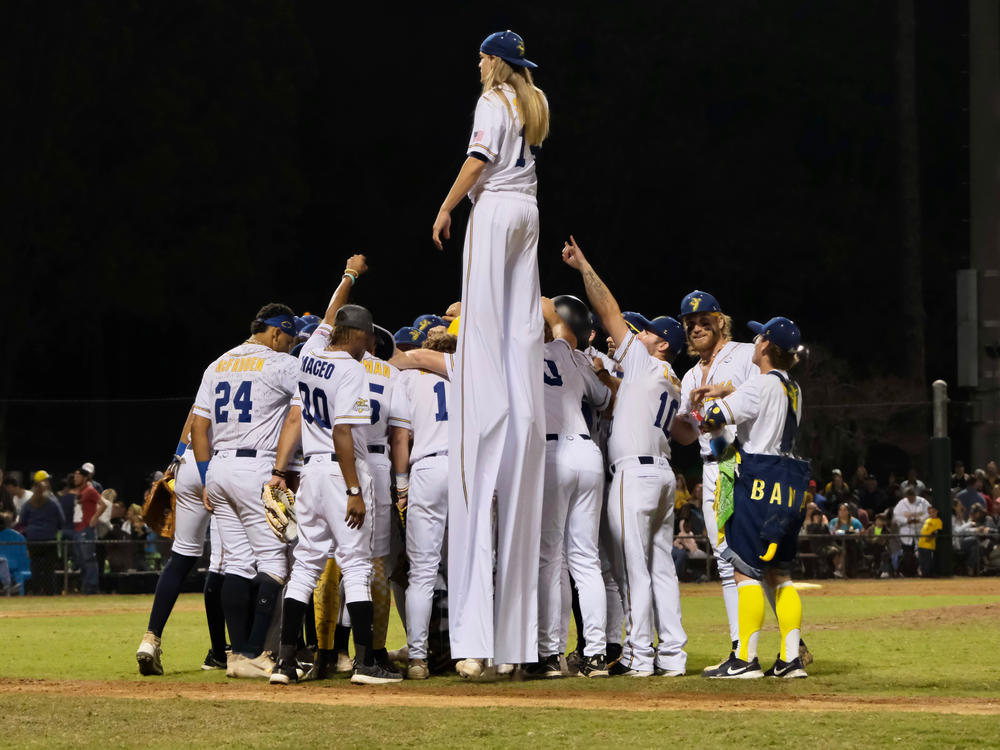 The Savannah Bananas huddle on the field at Grayson Stadium in Savannah, Georgia, before playing a team of retired Major League Baseball players on March 11, 2023.