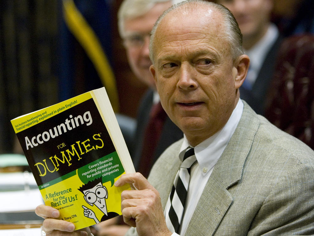 South Carolina Comptroller General Richard Eckstrom holds up a book he wanted to present to his new chief of staff during his introduction at a meeting on Aug. 13, 2009, in Columbia, S.C. Pressure is mounting for Eckstrom after a $3.5 billion accounting error.