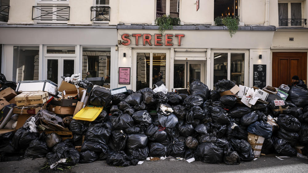 Uncollected garbage is piled up on a street in Paris on Wednesday during an ongoing strike by sanitation workers. Opponents of French President Emmanuel Macron's pension plan are staging strikes and protests as the contested bill heads toward a vote.