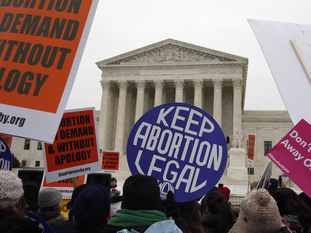 Pro-abortion rights signs are seen during the March for Life 2016 in front of the U.S. Supreme Court in Washington, on Jan. 22, 2016. The North Dakota Supreme Court ruled Thursday that a state abortion ban will remain blocked while a lawsuit over its constitutionality proceeds.