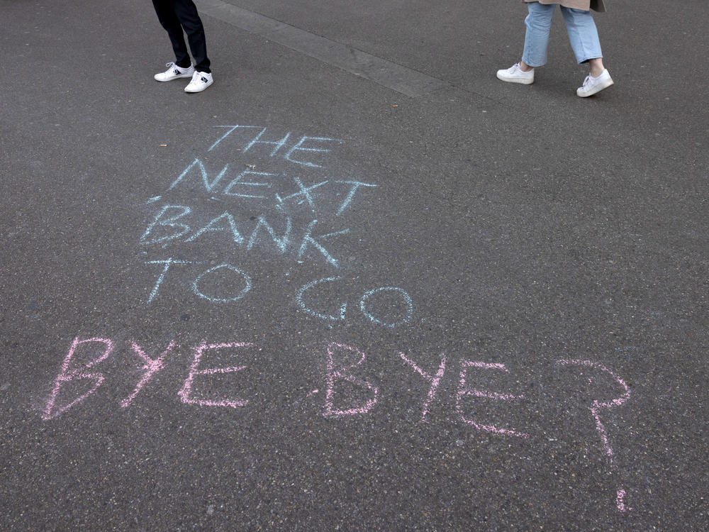 A slogan is written on the sidewalk in front of the global headquarters of Swiss bank Credit Suisse on March 16, 2023. Shares in Credit Suisse slumped earlier this week but recovered after receiving a lifeline from Switzerland's central bank.