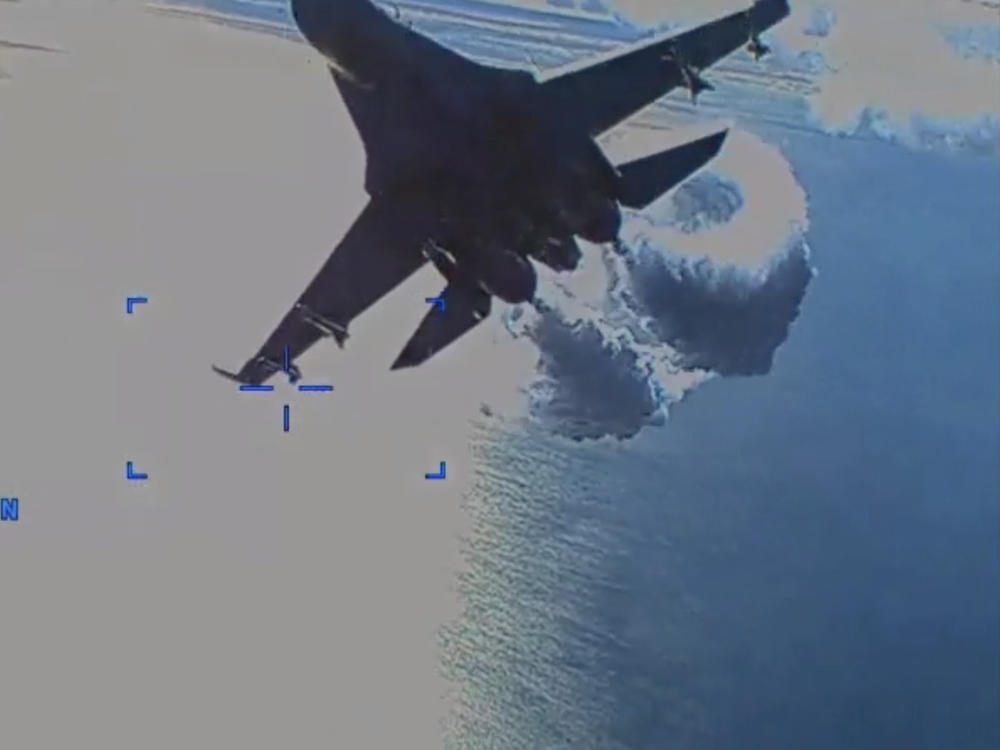 A Russian Su-27 fighter jet releases fuel as it approaches the rear of a U.S. Air Force MQ-9, in what the Pentagon says was 