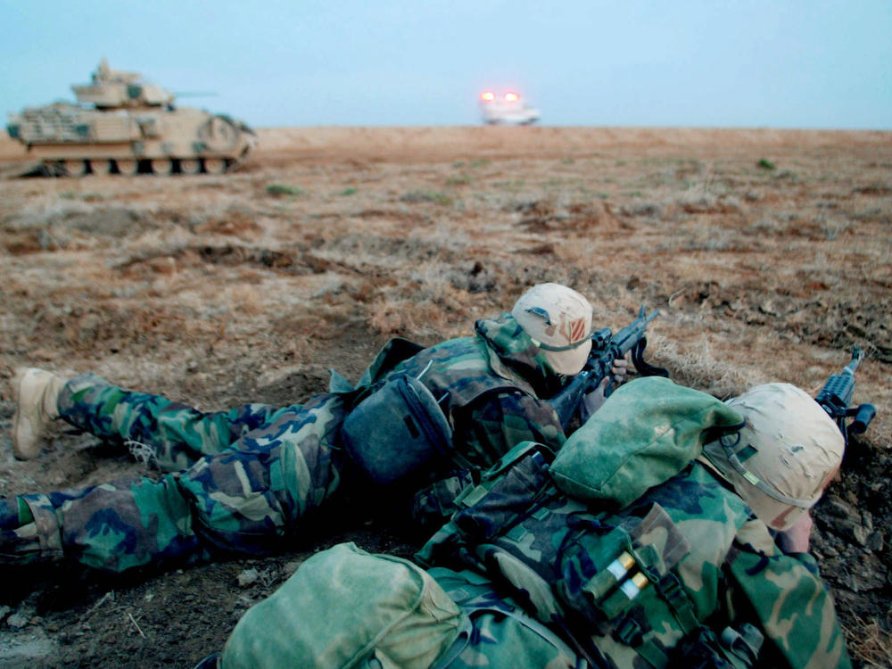 Soldiers of the U.S. Army 3rd Infantry Division secure a field near Najaf, Iraq, at sunrise on March 23, 2003.