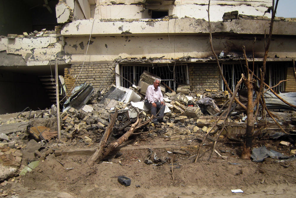 Sept. 20, 2010: A man sits on the rubble of his destroyed home a day after two near-simultaneous car bombs rocked Baghdad, killing 29 and wounding 111 in the city's deadliest day in a month.