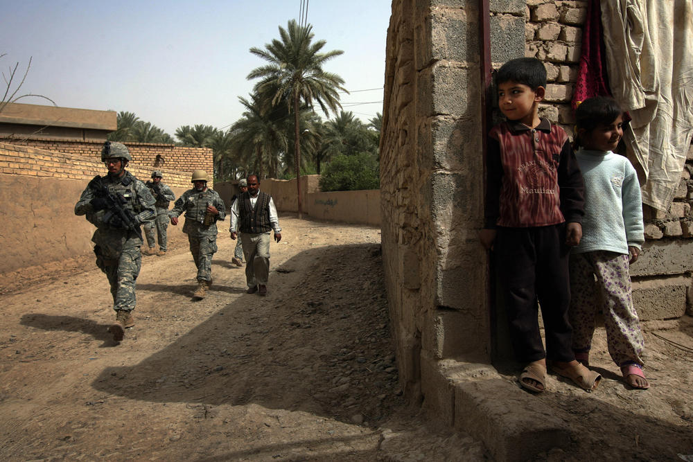 March 19, 2008: An Iraqi boy watches as U.S. soldiers patrol his neighborhood in the Diyala province, northeast of Baghdad.