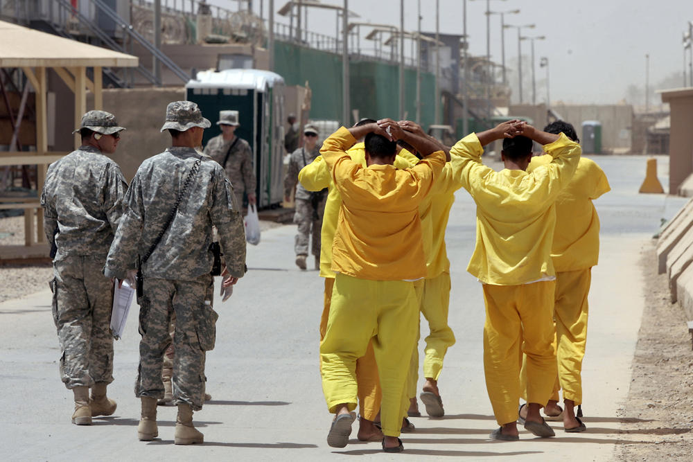 June 23, 2009: Iraqi prisoners hold their hands above their heads as they are escorted by U.S. soldiers from one unit to another at a U.S.-run detention center in Camp Cropper on the outskirts of Baghdad.