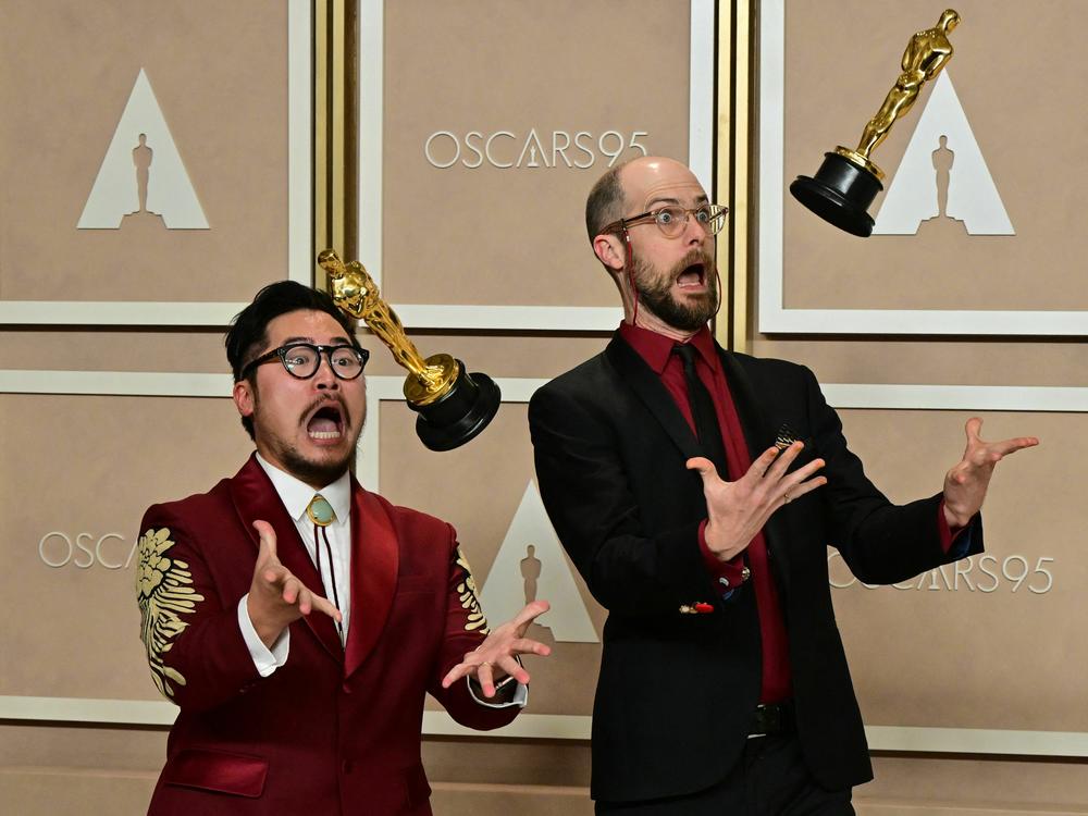 Directors Daniel Kwan (left) and Daniel Scheinert pose with their best director trophies for <em>Everything Everywhere All at Once.</em>