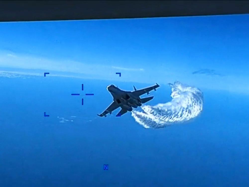 In a screen grab of a video clip released by the U.S. Defense Department's European Command, a Russian Su-27 fighter jet flies near a U.S. MQ-9 Reaper drone, spraying it with what appears to be jet fuel, on Mar. 14 over the Black Sea.