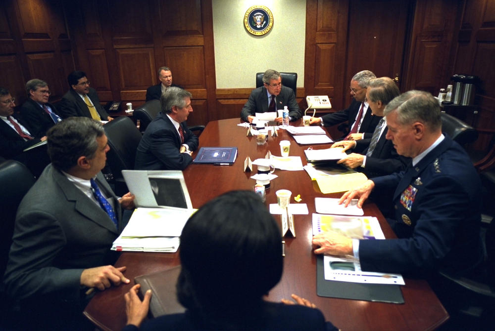 March 21, 2003: President George W. Bush meets with his war council in the Situation Room of the White House. Present at the table are, from foreground, National Security Adviser Condoleezza Rice, CIA Director George Tenet, Chief of Staff Andy Card, Secretary of State Colin Powell, Secretary of Defense Donald Rumsfeld and Chairman of the Joint Chiefs of Staff Gen. Richard B. Myers.