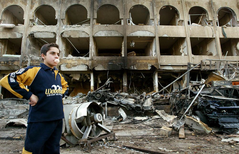Jan. 28, 2004: A boy stands at the scene of a car bombing that killed at least three people in Baghdad. A suicide bomber blew up the explosive-packed car in front of the Shaheen Hotel, which was frequented by many westerners and where Iraq's labor minister lived.