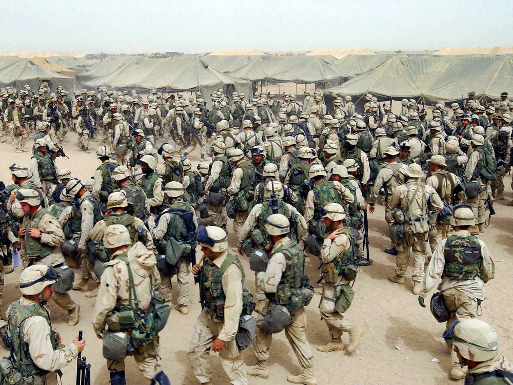 March 20, 2003: U.S. Marines prepare themselves after receiving orders to cross the Iraqi border at Camp Shoup, in northern Kuwait.