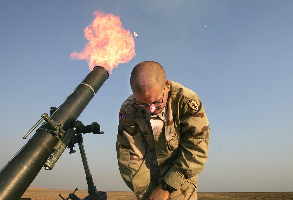 Jan. 17, 2005: Spc. Franklin Smith pulls away as a mortar blasts out of a tube at the edge of the U.S. airbase in Tal Afar, Iraq. U.S. mortaring teams frequently fired 
