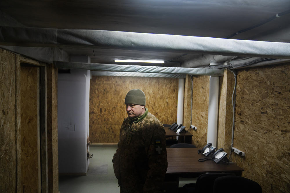 The bunker complex includes bedrooms, bathrooms, a kitchen and dining hall, office space, and a large central command room lined with desks and giant TV screens.