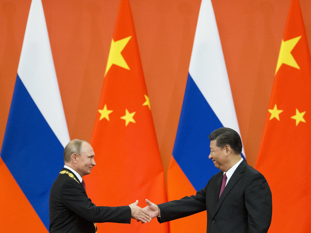 Chinese President Xi Jinping, right, and Russian President Vladimir Putin shake hands during an awarding ceremony at the Great Hall of the People in Beijing, China, on June 8, 2018. Xi is traveling to Moscow to show support for Putin.