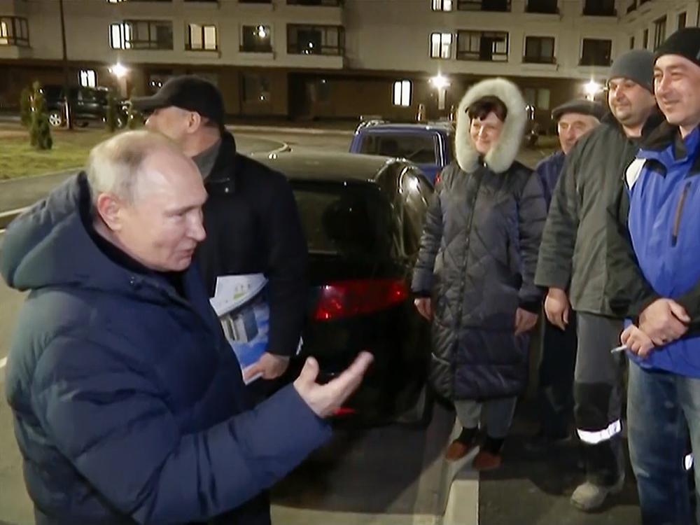 In this photo taken from video released by the Russian TV pool on Sunday, March 19, 2023, Russian President Vladimir Putin talks with local residents during a surprise visit to Mariupol.