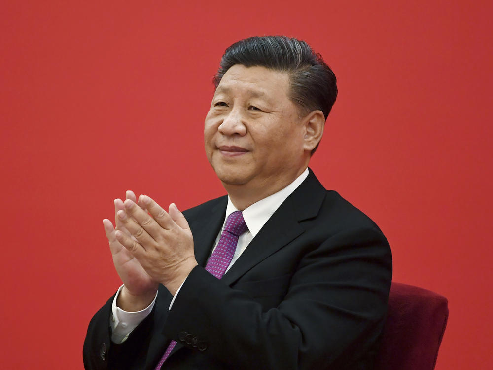 China's leader Xi Jinping claps as he listens to Russian President Vladimir Putin via a video link, from the Great Hall of the People in Beijing on Dec. 2, 2019. Xi will meet Putin this week on a visit to Moscow.