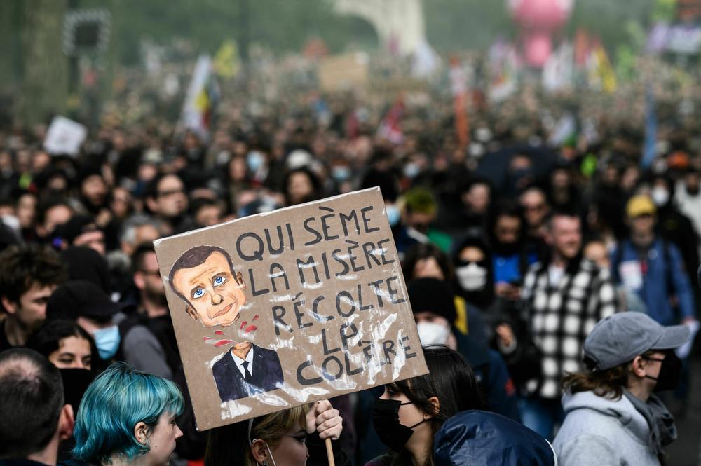 A protestor holds a sign reading 