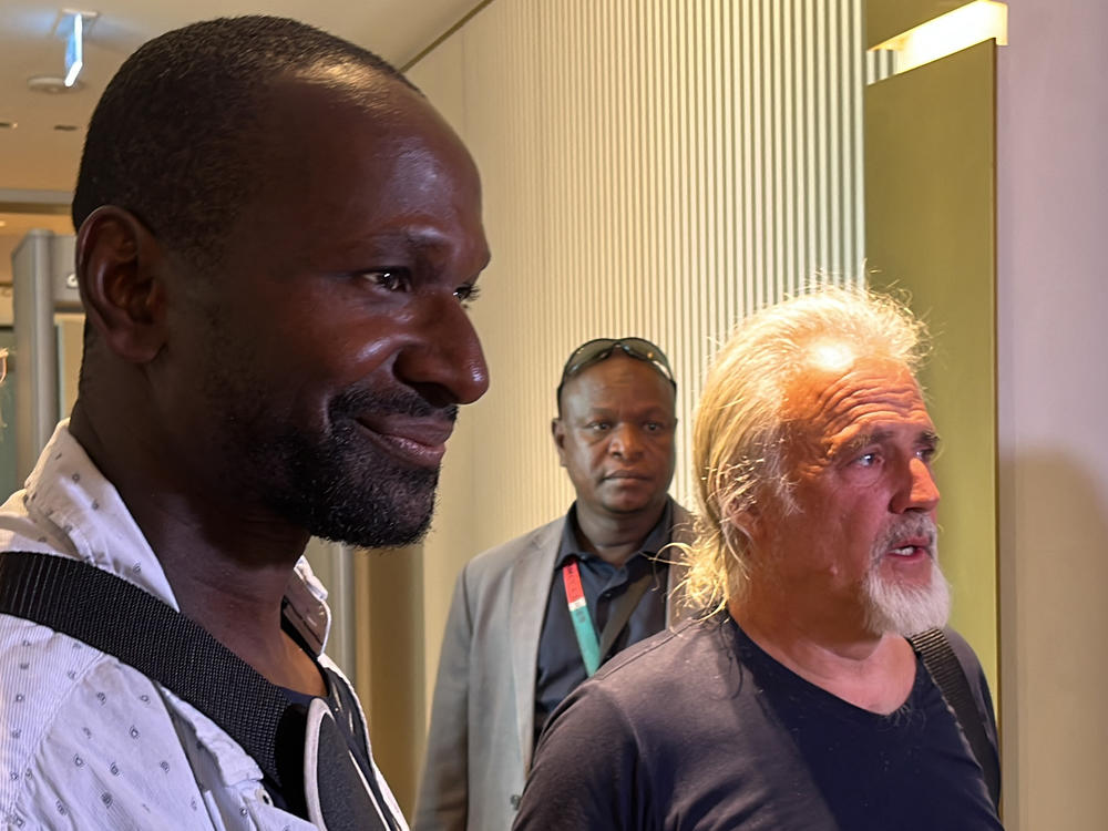 French journalist Olivier Dubois left, and Jeffery Woodke, right, are seen as they arrive at the Diori Hamani International Airport in Niamey on Monday.