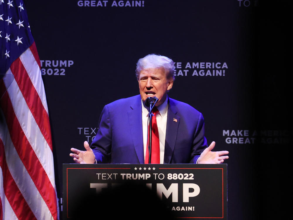 Former President Donald Trump, pictured here speaking to guests at Iowa's Adler Theatre last week, said on social media that he'll be arrested Tuesday as part of an investigation into hush money payments.