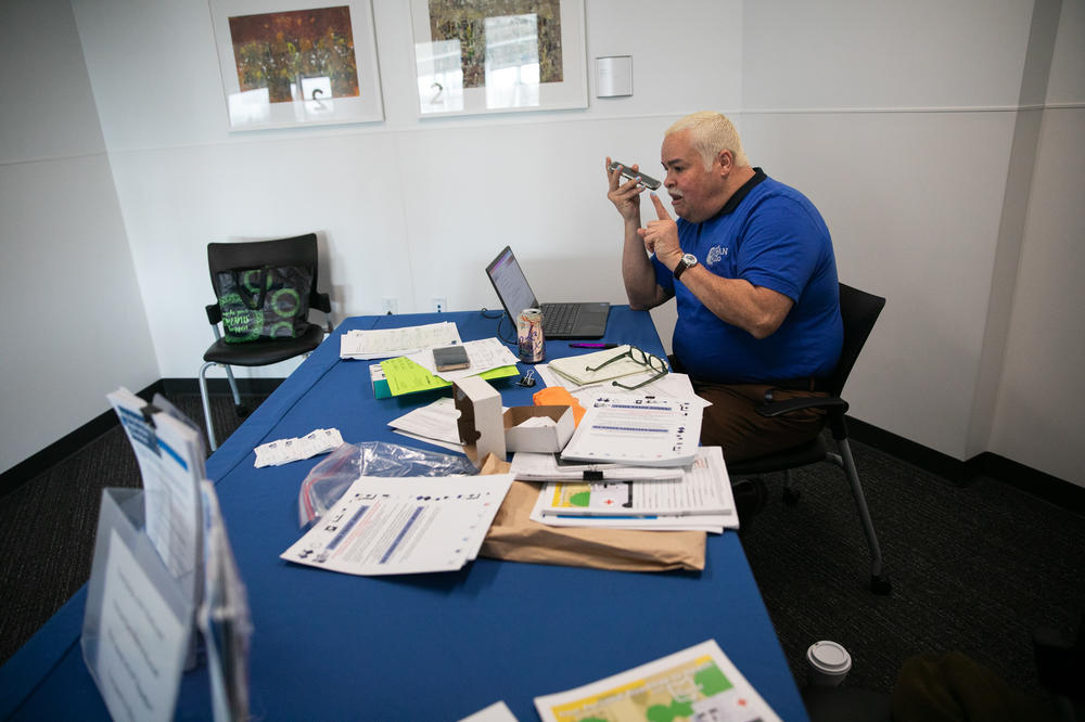 Camacho regularly sets up a table at the public library to help people with Medicaid enrollment. He says little errors in paperwork can lead to denials in the enrollment process.