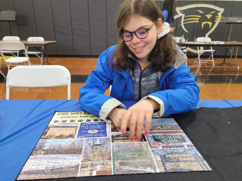Mora Leeb places some pieces into a puzzle during a local puzzle tournament. The 15-year-old has grown up without the left side of her brain after it was removed when she was very young.