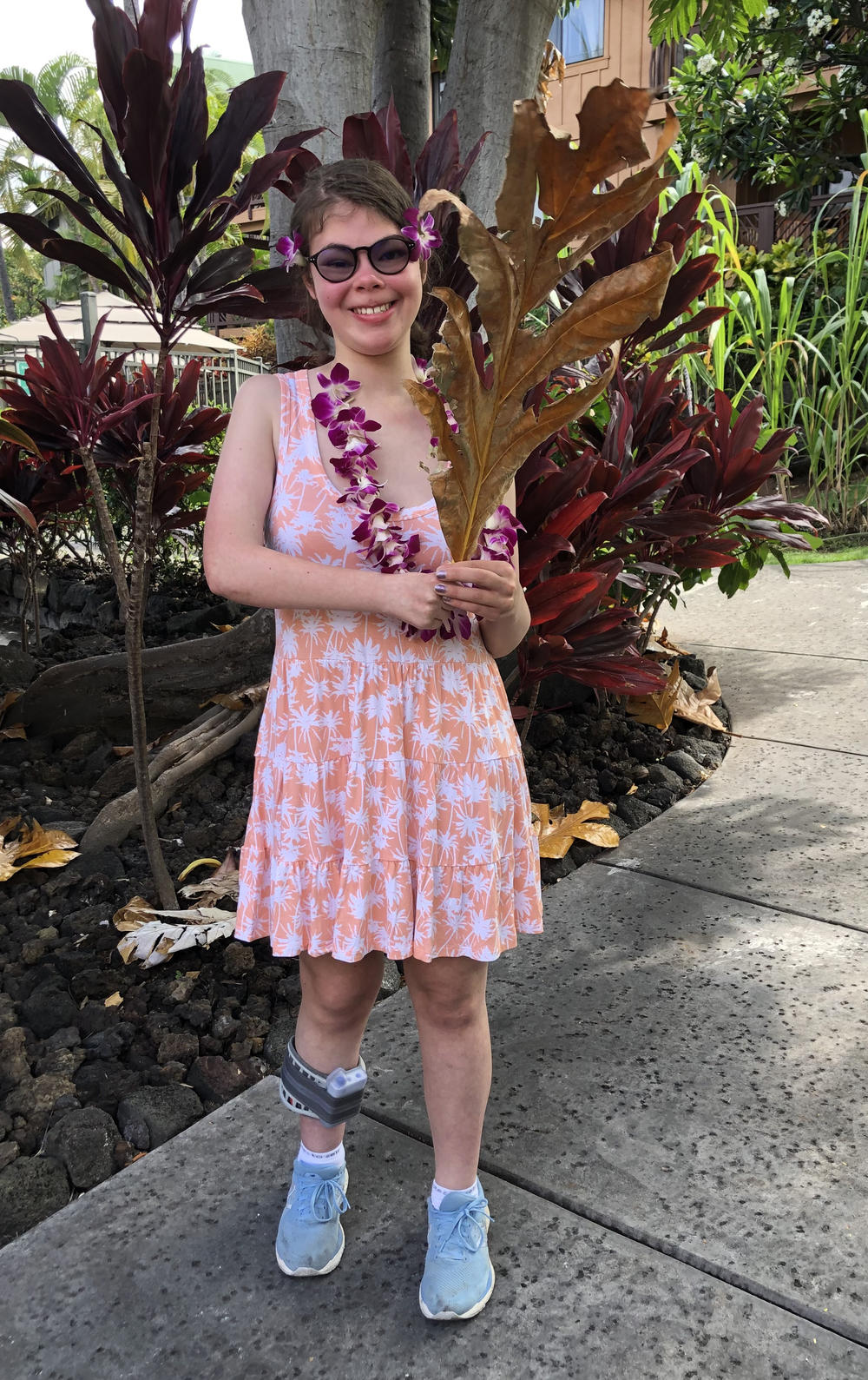 Mora holds a palm frond after stringing her own lei while on a family vacation.