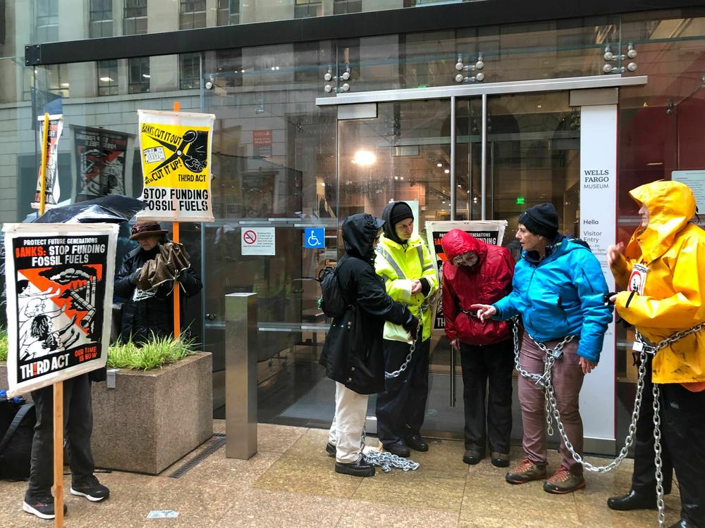 Protesters in San Francisco chained themselves together outside a Wells Fargo bank as part of a national effort to get banks to move away from investing in fossil fuel projects.