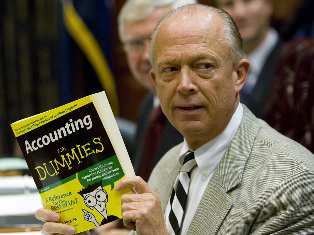South Carolina Comptroller General Richard Eckstrom holds up a book he wanted to present to his new chief of staff James Holly during his introduction a meeting on Aug. 13, 2009, in Columbia, S.C. Eckstrom is stepping down from his post after a $3.5 billion accounting error.