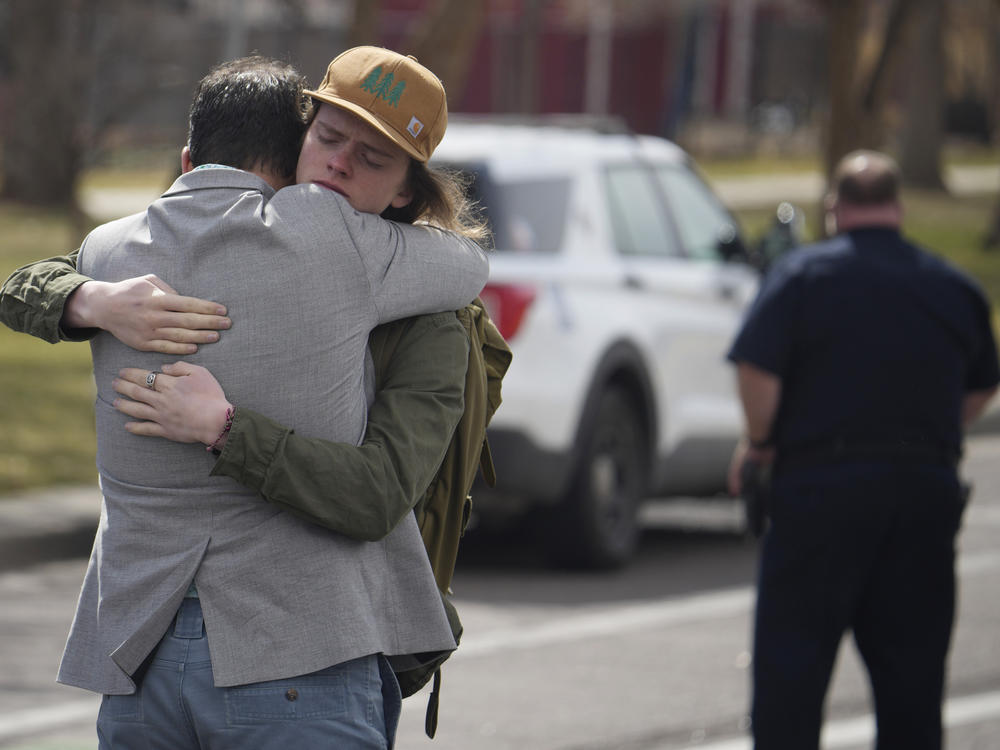 A student hugs a man after a school shooting at East High School Wednesday in Denver.