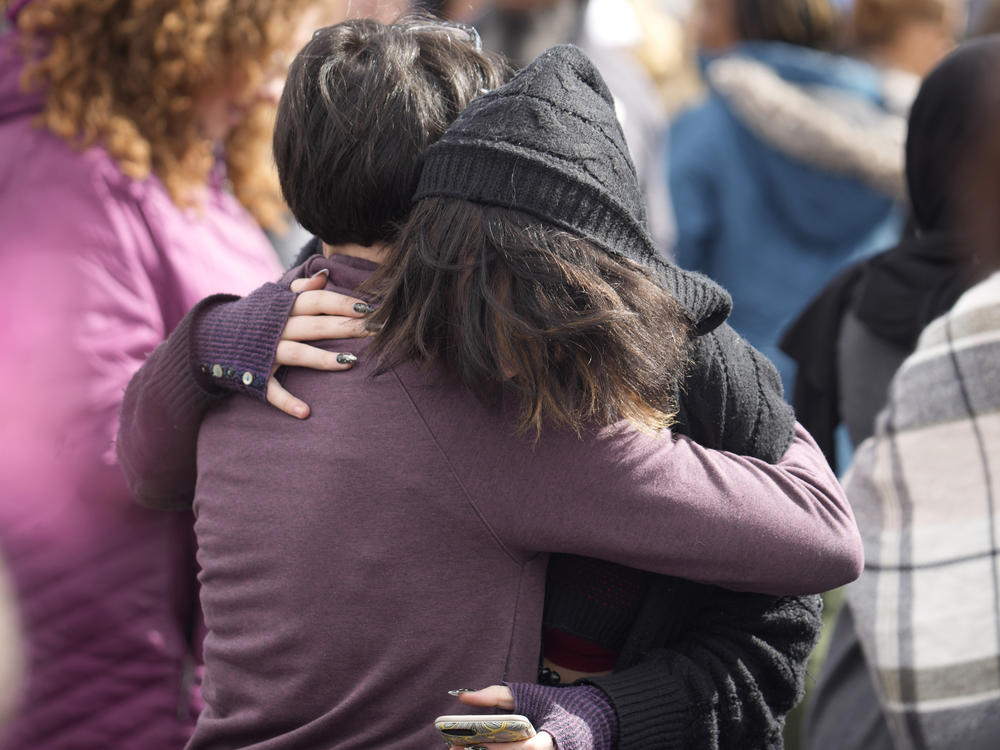 A parent hugs a student as they are reunited after a school shooting at East High School Wednesday, March 22, 2023, in Denver. Two school administrators were shot at the high school Wednesday morning after a handgun was found on a student subjected to daily searches, authorities said.