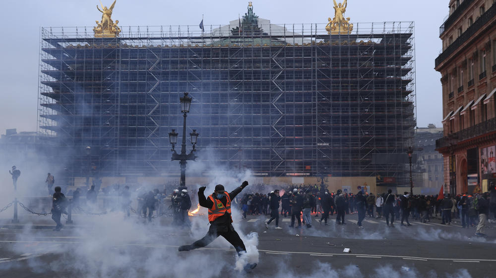 A protester kicks a tear gas canister in front of the Opera at the end of a rally in Paris on Thursday.