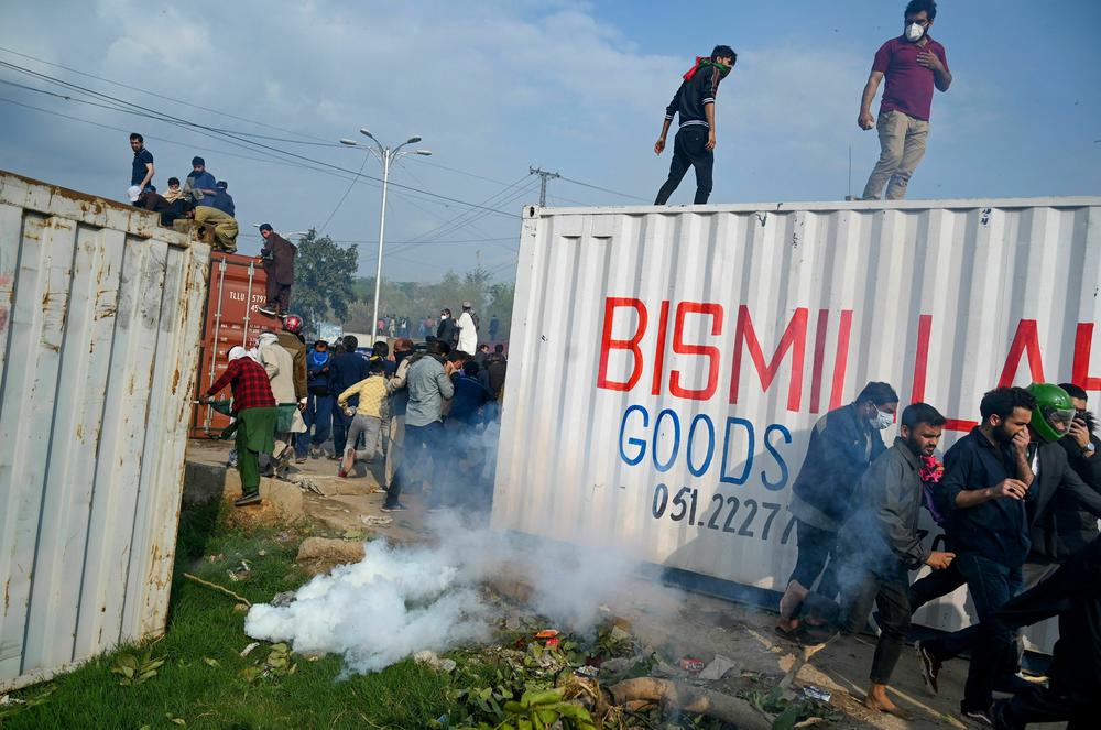 Policemen fire tear gas to disperse supporters of Pakistan's former Prime Minister Imran Khan, outside a court in Islamabad on March 18.