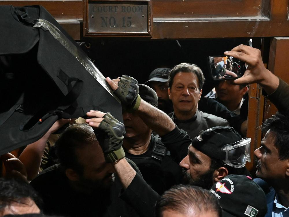 Pakistan's former prime minister Imran Khan (center) leaves after appearing before a court for a protective bail in relation to two cases, in Lahore on March 21. Khan spoke to NPR's <em>Morning Edition</em> on Thursday.