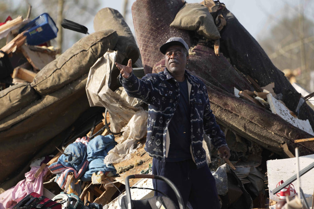 A resident looks through the piles of debris, insulation, and home furnishings to see if anything is salvageable in Rolling Fork, Miss.