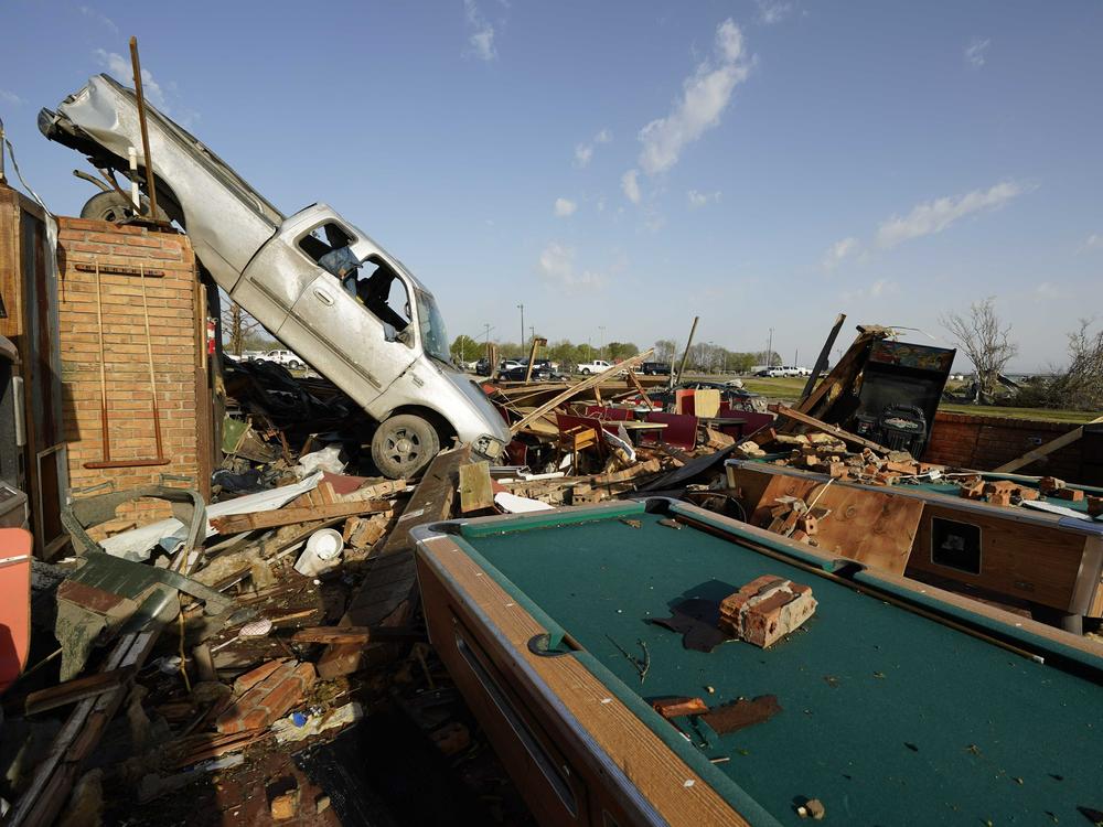 A pickup truck rests on top of a restaurant cooler at Chuck's Dairy Cafe in Rolling Fork, Miss. Emergency officials in Mississippi say several people have been killed by a tornado that tore through the state on Friday night, destroying buildings and knocking out power as severe weather produced hail the size of golf balls moved through several southern states.