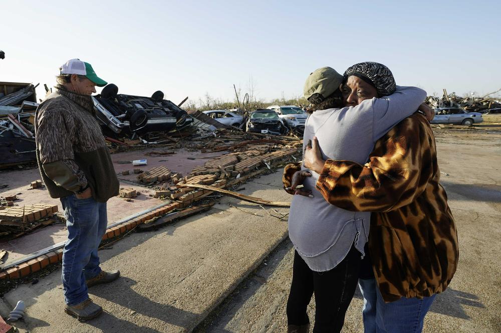 Tracy Hardin, center, who with her husband Tim, left, own Chuck's Dairy Bar, consoles a neighbor in Rolling Fork, Miss. The couple and their six employees were hiding in the cooler when the tornado hit.