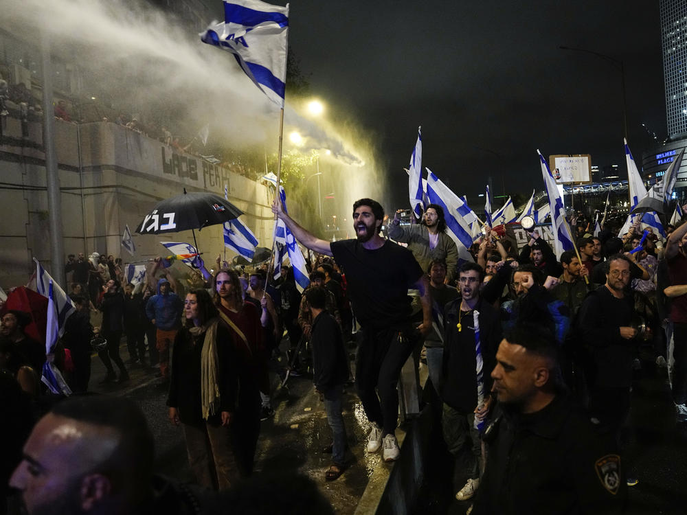 Israeli police use a water cannon to disperse demonstrators blocking the freeway during a protest against plans by Prime Minister Benjamin Netanyahu's government to overhaul the judicial system in Tel Aviv, Israel, on Saturday.